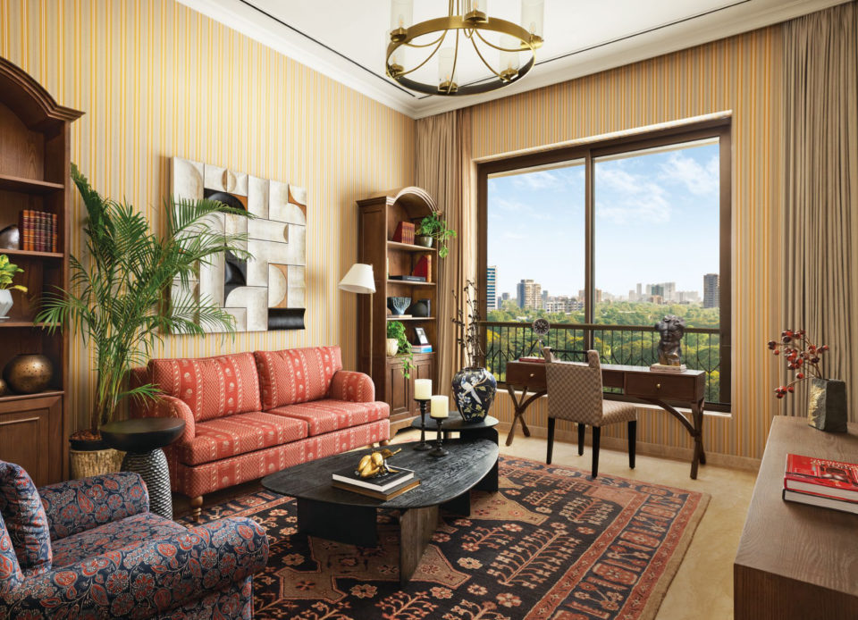 Study and family lounge with a red sofa, bookshelves and a large window